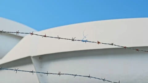 Rusty Barbed Wire with String of Nylon Material Moving in the Wind Stock Footage 220651962