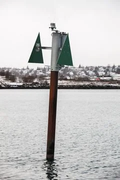 Rusty beacon pole with green triangular top mark shape pointing up Stock Photos