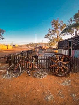 Rusty bicycle and wagon wheel in australian outback Stock Photos
