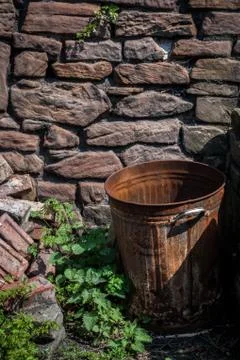 Rusty Bin by Stone Wall Stock Photos
