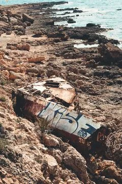 Rusty boat and party stranded on the beach Stock Photos