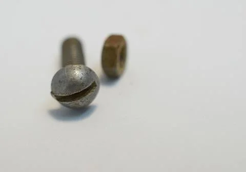 Rusty bolt and nut lie next each other on gray background Stock Photos