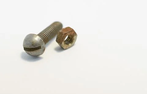Rusty bolt and nut lie next each other on gray background Stock Photos