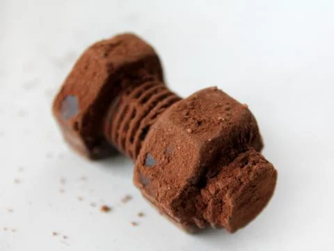 Rusty bolt and nut made of chocolate isolated on white background Stock Photos
