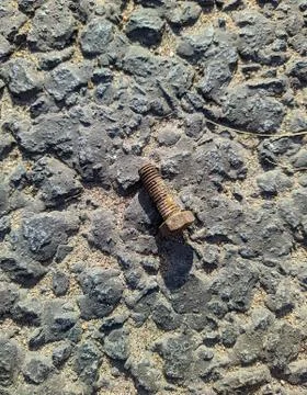 Rusty bolt on the asphalt in the daytime Stock Photos