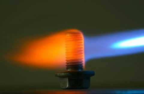 Rusty bolt in a flame of a gas torch. Stock Photos