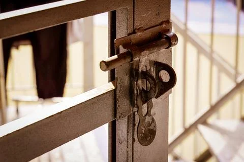 A rusty bolt lock on a metal gate in soft light Stock Photos