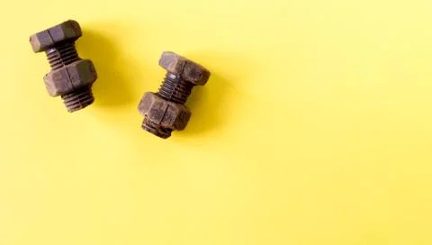 Rusty bolts and nuts made of chocolate isolated on yellow background Stock Photos