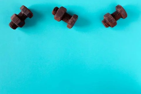 Rusty bolts and nuts made of chocolate isolated on sky blue background Stock Photos
