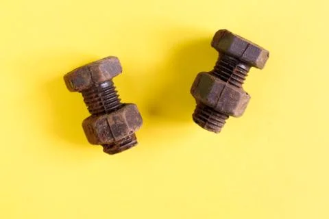 Rusty bolts and nuts made of chocolate isolated on yellow background Stock Photos