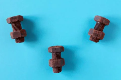 Rusty bolts and nuts made of chocolate isolated on blue background Stock Photos