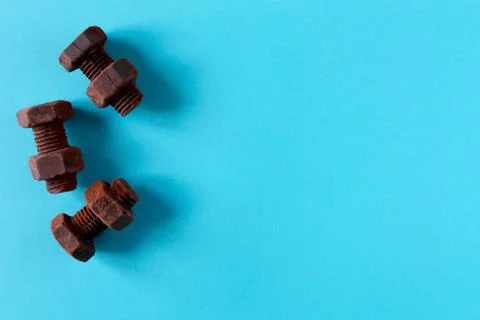 Rusty bolts and nuts made of chocolate isolated on sky blue background Stock Photos