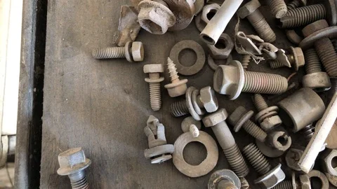 Rusty bolts and nuts scattered on the old garage table Vidéo 105717705