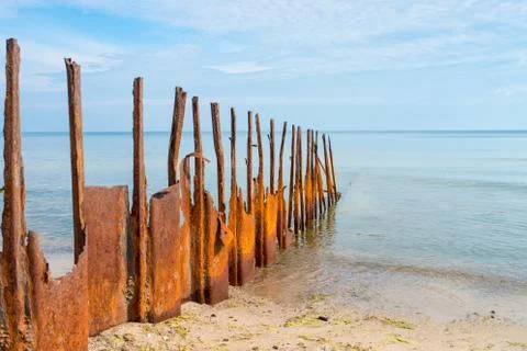 Rusty breakwater with the sea in the background Stock Photos