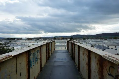 Rusty Bridge View Over Caravan Park In Towyn, North Wales, Under Cloudy Sky. Stock Photos