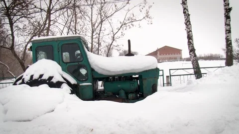 Rusty broken tractor in the snow. Disabled equipment. Closeup view. Stock-Footage 117843497