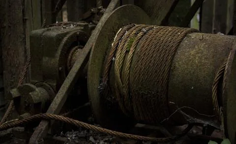 Rusty cable drum and winch mechanism covered in moss and decay Stock Photos