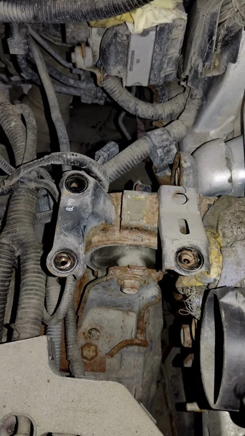 A rusty car engine mount bracket surrounded by wiring looms. Stock Footage 339491504