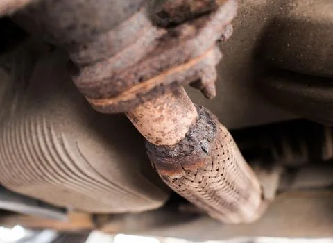 Rusty car exhaust flex pipe with a broken weld Stock Photos