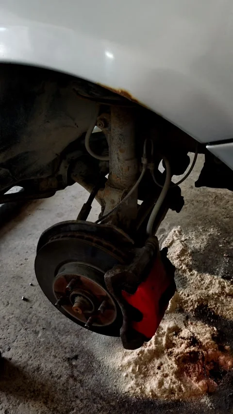 Rusty car front suspension with red brake caliper and rotor Stock Footage 334321638