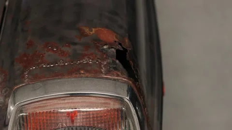 Rusty car metal with broken taillight detail in close-up outdoor setting Stock Footage 308159883