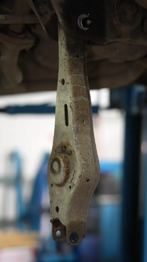A rusty car rear lower control arm hanging from subframe. Stock Footage 345912025