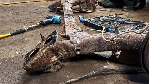 Rusty car subframe undergoing automotive repair at a mechanic workshop garage Stock Footage 328089540