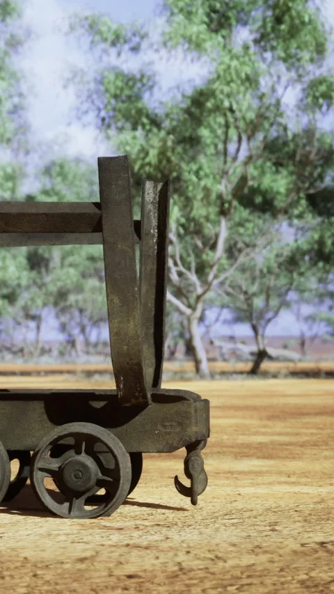 Rusty cart on dry ground with trees in background near water Stock Footage 334247473