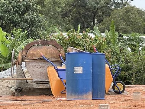 Rusty Cement Mixer at Construction Site with Tools and Natural Background Stock Photos