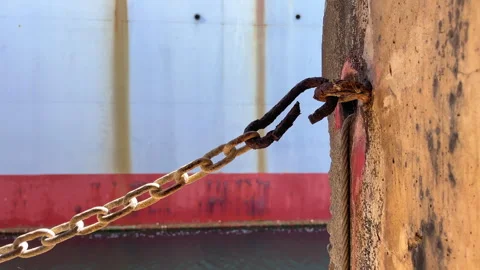 Rusty chain and cable securing an old docked structure, symbolizing maritime Stock Footage 301854541