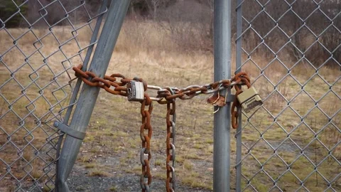 Rusty chain and locks keeping a fence closed Stock Footage 260415737