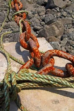 Rusty chain and rope secured to an anchor point on the floor of the Minas B.. Foto stock