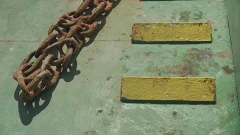 Rusty chain on green ship deck with yellow nonslip strips, peeling paint, heavy Stock Footage 335636697