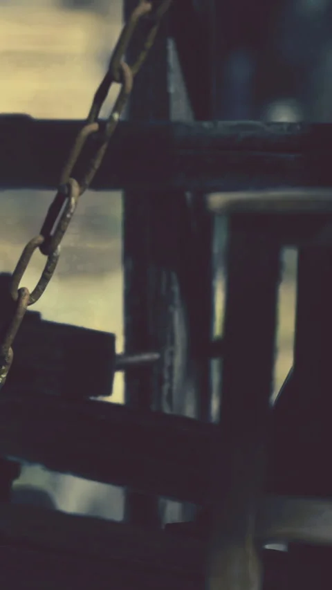Rusty chain hangs on wooden structure in an old workshop during daylight Stock Footage 336430673