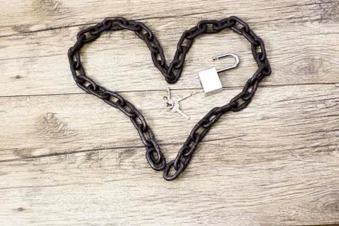 Rusty chain heart shape with open lock. Stock Photos