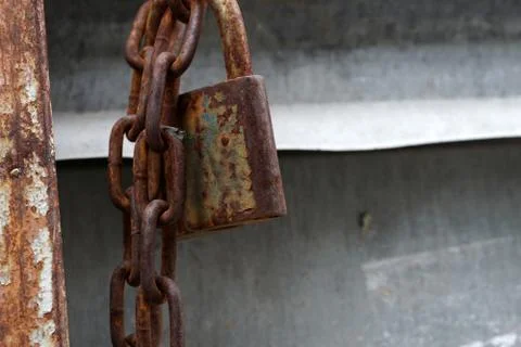 Rusty chain with padlock hanging on a construction site.. Stock-Fotos