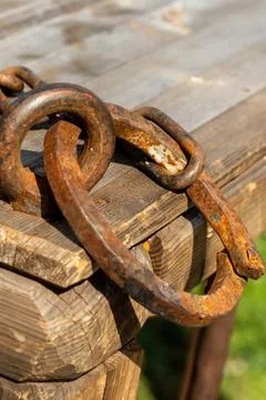 Rusty chain ring on the edge of a wooden old steel close-up Stock Photos