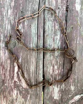 Rusty chain. Rusty chain links on a background of old wood. Stock Photos
