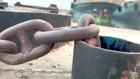 Rusty chain wrapped around a metal bollard on a dock Stock Footage 335442443