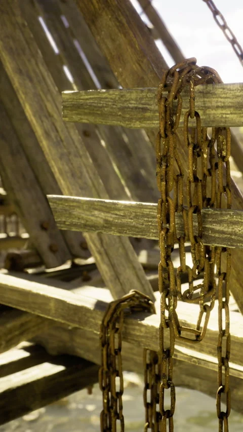 Rusty chains hang on weathered wood at serene seaside location Stock Footage 331806812