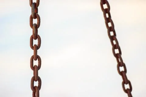 Rusty chains on a light background, part in the focus. punishment, fastening. Stock Photos