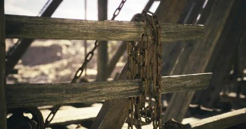 Rusty chains on weathered beams in an abandoned, rocky area Stock Illustration