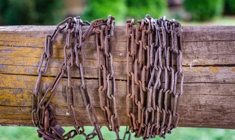 Rusty Chains Wrapped Around a Weathered Wooden Post Stock Photos