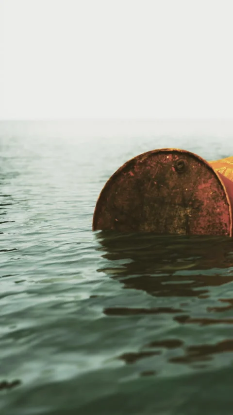 Rusty circular object floats peacefully on calm water surface during dawn Vídeos de archivo 334257475