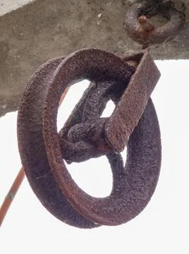 Rusty, cobwebbed pulley in an old stone well Stock Photos