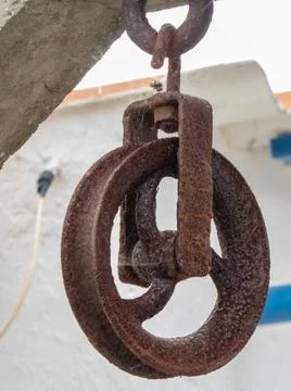 Rusty, cobwebbed pulley in an old stone well Stock Photos