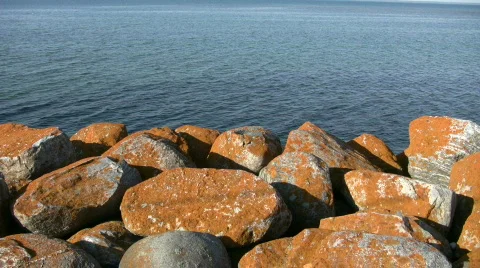Rusty colored rocks foreground a beautiful ocean view (High Definition) Stock-Footage 360347