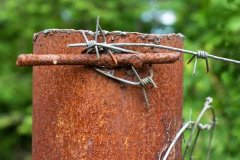 Rusty column with barbed wire Stock Photos