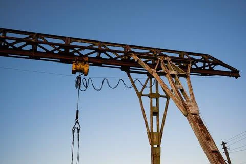 Rusty construction crane against clear blue sky, industrial equipment and u.. Stock Photos