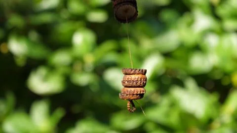Rusty covers hang on a thread pierced through them Stock Photos